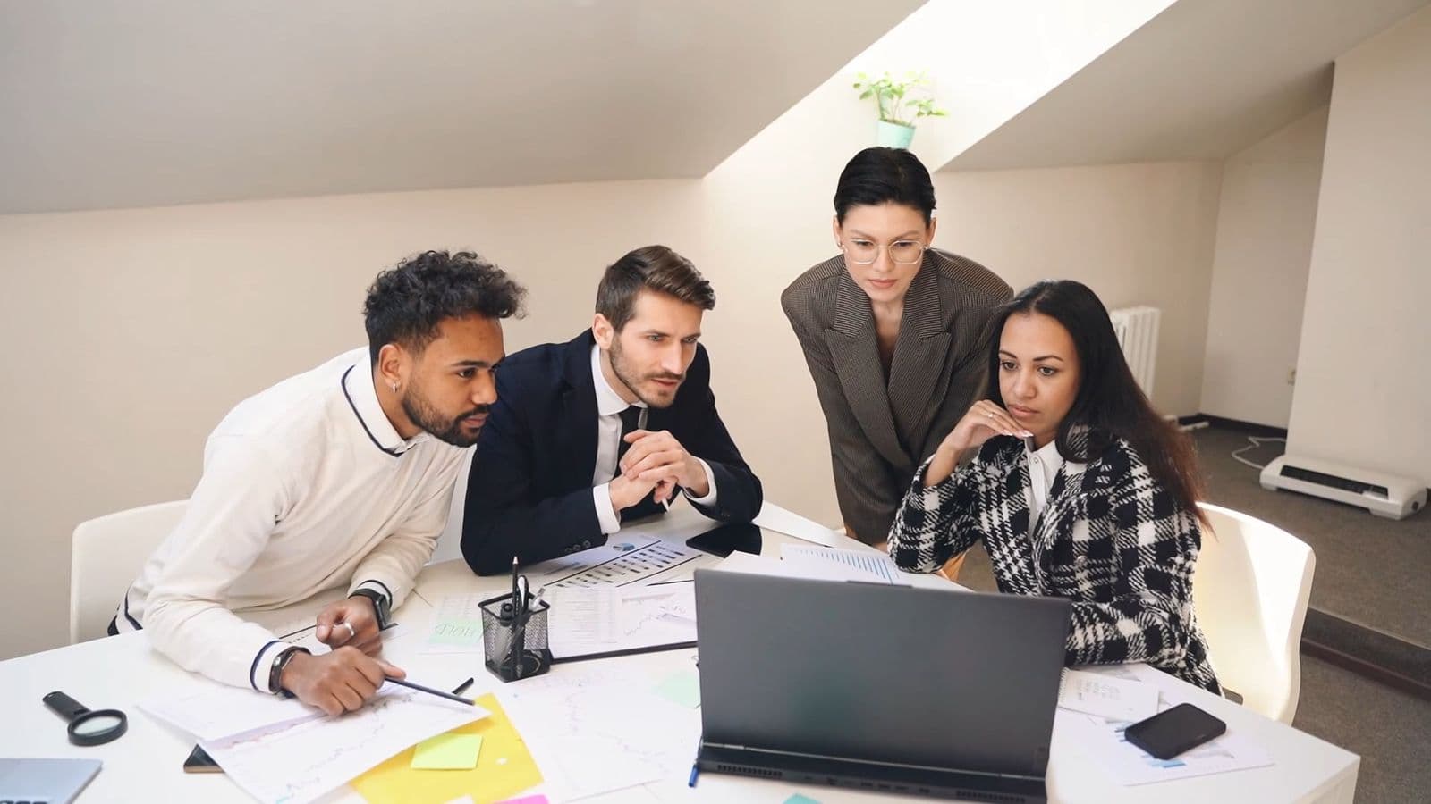 Équipe de professionnels analysant les données d'un projet digital autour d'un ordinateur portable